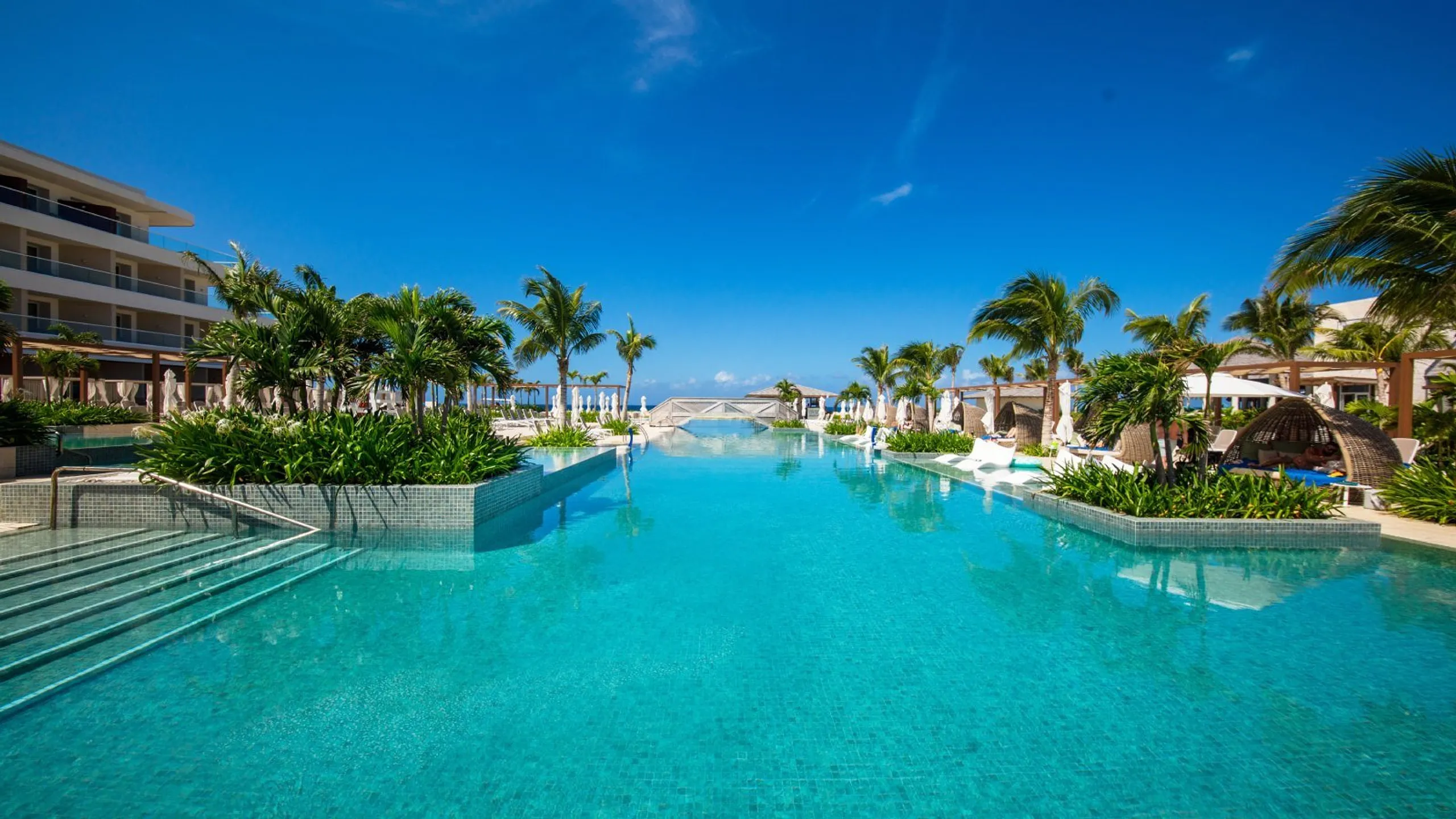 The main pool at Princess Grand Jamaica, palms along the water and the sea beyond